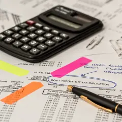 Chcesz wiedzieć, jak pobrać wyciąg z konta ipko? Na zdjęciu kalkulator i dokumenty, które mogą pomóc w analizie finansowej.