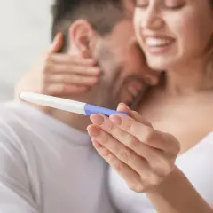 Szczęśliwa para trzyma test ciążowy. Czy jestem w ciąży? Radość i nadzieja w ich oczach.
