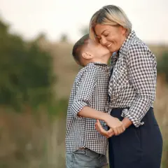 Un bambino bacia la guancia della madre, un gesto d'amore che dimostra che chi ha la mamma è ricc e nun o sap, una vera poesia.