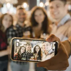 Grupa przyjaciół robi sobie zdjęcie grupowe telefonem. Oto jak zrobić selfie telefonem, by uchwycić wspólne chwile.