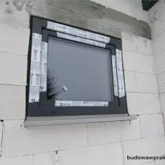 Okna zamontowane w ścianie z bloczków betonowych, budynek w stanie surowym zamkniętym. Taśma uszczelniająca Drutex.
