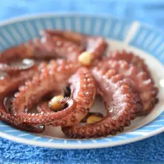 Gotowy ośmiorniczki przepis na talerzu. Delikatne macki z czosnkiem, gotowe do podania.