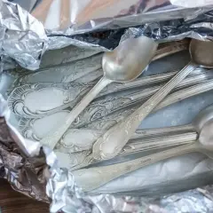 Stare, ozdobne łyżki w folii aluminiowej, gotowe do czyszczenia srebra solą.