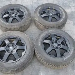 Cztery czarne felgi z oponami Yokohama Geolandar A/T, idealne do Subaru Outback Wilderness, gotowe na każdą przygodę.