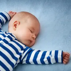 Śpiący chłopczyk w pasiastym pajacyku. Może to inspiracja na oryginalne imiona dla chłopców?