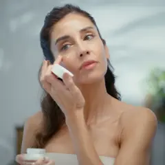 Kobieta aplikuje krem pod oczy, który zawiera ceramid AP, dbając o nawilżenie i regenerację skóry.