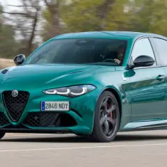Un Alfa Romeo Giulia verde es conducido en una carretera, con el conductor visible al volante. Es una prueba del coche.