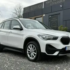 Białe BMW iX1 przed salonem samochodowym. Sprawdź atrakcyjną bmw ix1 cena!