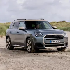 Grå Mini Countryman på sandig väg vid en strand. En spännande mini countryman test i en unik miljö.
