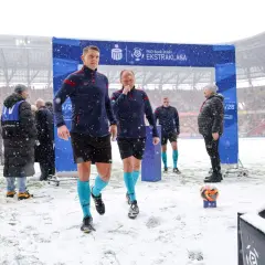 Sędziowie w śnieżny dzień wchodzą na boisko przed meczem Jagiellonia Białystok – GKS Katowice.