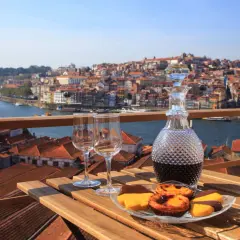 Un bicchiere di **douro vino** e dolci su un tavolo con vista su Porto.