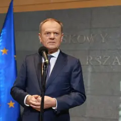 Premier Tusk, stojąc przed flagami Polski i UE, przemawia na tle napisu "Warszawa-Okęcie". Kto poparł zielony ład?