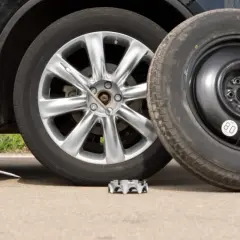 Changement de roue avec cric. Le prix de la réparation d'un pneu peut varier.