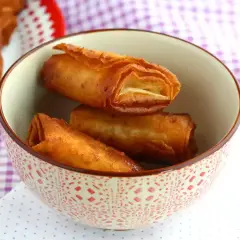 Krispiga, gyllene rullar med friterad banan panko i en mönstrad skål.