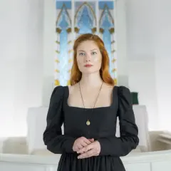 Elegancki, czarny ubiór do kościoła, z kwadratowym dekoltem i bufiastymi rękawami, podkreśla powagę chwili.