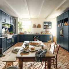 Geräumige Küche im mediterranen Landhausstil mit dunklen Schränken, Holztisch und Terrakotta-Boden.