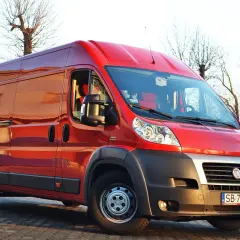 Czerwony Fiat Ducato Maxi zaparkowany na zewnątrz, gotowy do transportu.