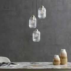 Eleganckie lampy loftowe z przezroczystego szkła wiszą nad marmurowym blatem.