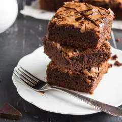 Stos puszystych brownie na talerzyku, idealne na zdrowe przekąski. Szukasz ciasta fit przepisy? Oto one!