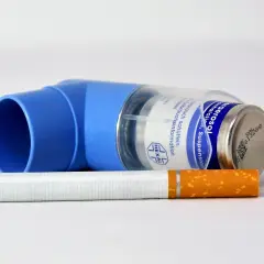 Niebieski inhalator Ultibro i papieros na białym tle.