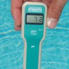 Un appareil mesure le ph de l'eau d'une piscine. L'écran affiche 7.2, un niveau idéal pour la baignade.