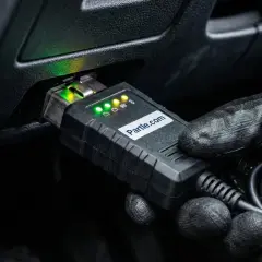 Rękawica podłącza urządzenie diagnostyczne do portu OBD. Wskaźniki LED świecą, sygnalizując gotowość do analizy parametrów, w tym kąta wyprzedzenia zapłonu.