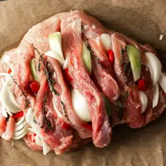 Surowa szynka z cebulą, papryczką chili i ziołami, gotowa na pyszny obiad.