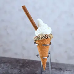 En mjukglass av vanlig glass, med strössel och en chokladpinne, serveras i ett krispigt våffelstrut.