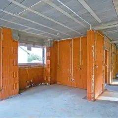 Budowa domu w toku: ściany z pustaków ceramicznych, instalacja elektryczna, okna. Sprawdź nasze usługi elektryczne cennik.