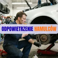 Mechanik wykonuje odpowietrzanie hamulców w warsztacie samochodowym.