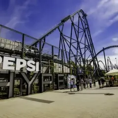 Energylandia opinie: ogromna kolejka górska Pepsi z ludźmi w tle.
