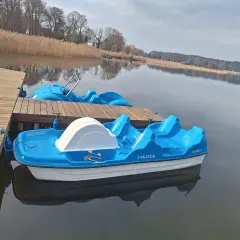 Błękitne rowerki wodne czekają na gości przy drewnianym pomoście. To idealne miejsce na wypoczynek, jak w słynnym polu namiotowym Sława.