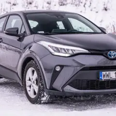 Szara, używana Toyota C-HR na śniegu. Stylowy crossover gotowy na zimowe wyzwania.
