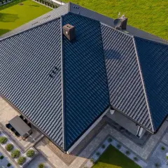 Nowoczesny dom z ciemnym dachem z dachówki ceramicznej. Różne rodzaje dachówek tworzą harmonijną całość.