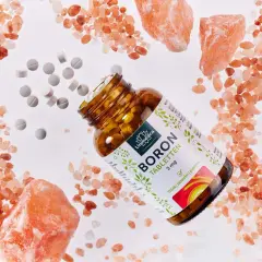 Braune Glasflasche mit BORON Tabletten, umgeben von rosa Salzkristallen und verstreuten Tabletten. Ein natürliches bor vitamin für Ihr Wohlbefinden.
