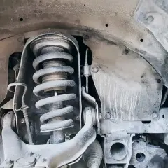 Primer plano de un amortiguador de coche, parte esencial para el confort y la seguridad.
