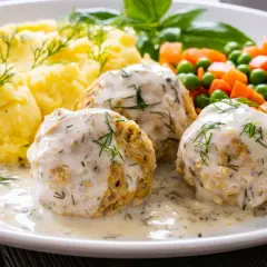 Pyszne pulpety z indyka w sosie koperkowym, podane z puree ziemniaczanym i warzywami.