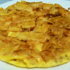 Tortilla de macarrones dorada y apetitosa, con trozos de pasta integrados en el huevo. ¡Un plato casero perfecto!