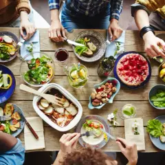 Leckeres Essen auf dem Tisch, aber was hilft gegen Appetit? Nüsse und frisches Gemüse sind eine gesunde Wahl.