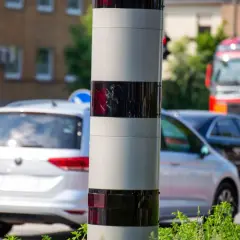 Ein Blitzer ohne Blitz: Dieses Gerät überwacht den Verkehr. Autos fahren vorbei, ein roter LKW ist im Hintergrund zu sehen.