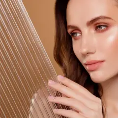 Kobieta z idealną cerą, która emanuje zdrowiem i blaskiem, osiągając efekt glass skin. Jej skóra jest gładka i świetlista, niczym tafla szkła.