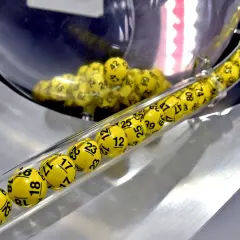 Żółte kulki z numerami, jak w grze multi multi zasady, toczą się w przezroczystej tubie.