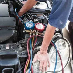 Mechanik sprawdza ciśnienie w układzie klimatyzacji. Objawy zapchanego osuszacza klimatyzacji mogą być trudne do zdiagnozowania.