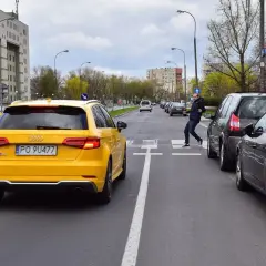 Mężczyzna przechodzi przez pasy, podczas gdy samochody blokują przejście dla pieszych. Żółty Audi stoi na pasach.