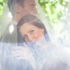 Para młoda pod welonem, z welonu przebija światło, tworząc efekt flary.