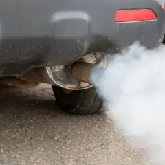 Fumo bianco dalla marmitta diesel di un'auto, che si disperde nell'aria.