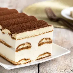Tiramisù cremoso, uno dei dolci senza glutine perfetti per ogni occasione. Strati di savoiardi e crema, spolverati di cacao.