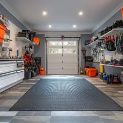 Un garage ordinato con pareti grigio-azzurro e arancioni contenitori. Ottima ispirazione su di che colore pitturare il garage per un look moderno e funzionale.