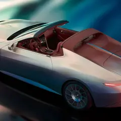 Lussuosa BMW Skytop cabriolet color argento con interni in pelle rossa, su sfondo blu sfumato.