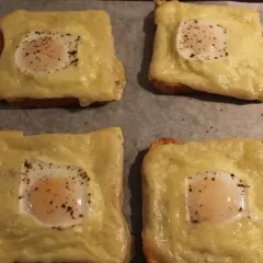 Fyra varma mackor i ugn med smält ost och ett ägg på varje. Perfekt för en snabb och god måltid.